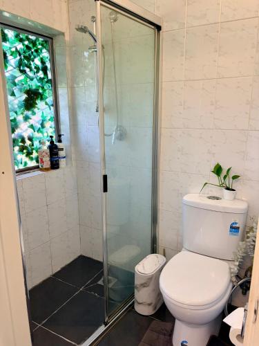 a bathroom with a toilet and a glass shower at Mystic Garden Private Entry & Bath, Pet Friendly in Wentworthville