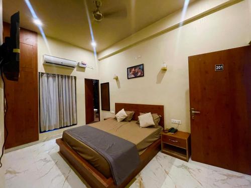 a bedroom with a bed and a window and a door at Green hillock hotel in Alwar