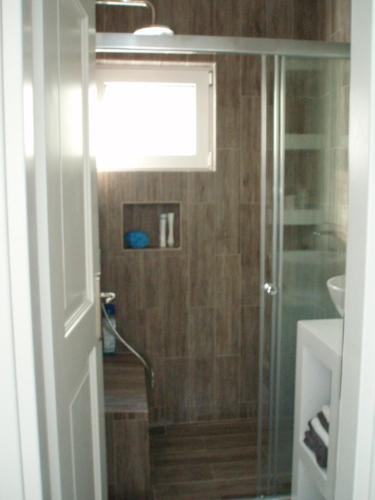 a bathroom with a shower with a glass door at Villa Marcyr in Kamilari