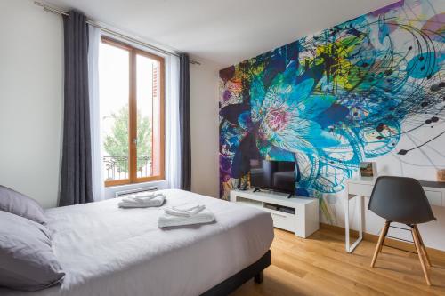 a bedroom with a bed and a painting on the wall at The Pearl in Vitry-sur-Seine