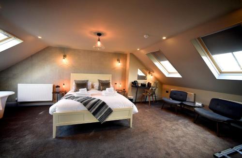 a bedroom with a large bed in a room with skylights at Thornham Rooms at The Chequers in Thornham