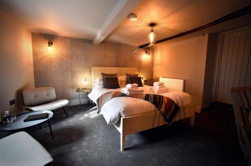 a hotel room with two beds and a chair at The Chequers Inn, Thornham in Thornham