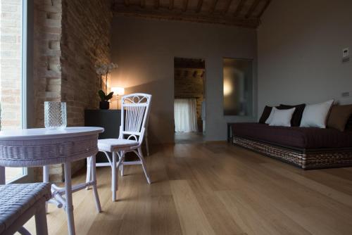 a living room with a bed and a table and chairs at Villa Anitori Prestige Relais & Spa in Loro Piceno