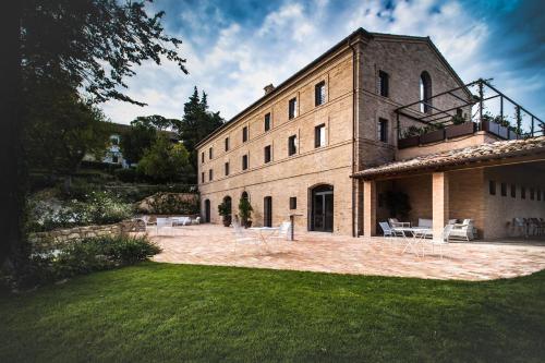 Un grand bâtiment en briques avec un balcon est disponible. dans l'établissement Villa Anitori Prestige Relais & Spa, à Loro Piceno
