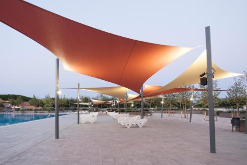 a group of umbrellas on a patio next to a pool at Camping Riembau in Platja  d'Aro