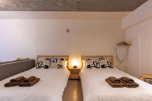 two beds with towels on them in a room at Rafaye N16 in Sapporo