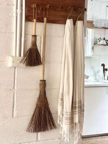 a group of broomsticks hanging on a wall at Villa Saint George Byron Hinterland in Clunes