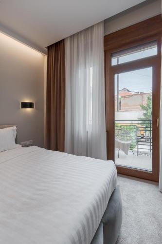a bedroom with a large bed and a sliding glass door at Oasis Rooms Oradea in Oradea