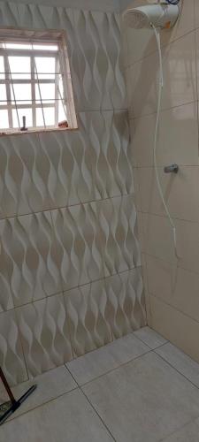 a bathroom with a shower with ailed wall at Pousada e Pesqueiro Recanto do Peixe in Carmo do Rio Claro