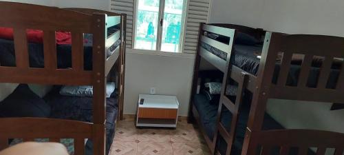 a room with two bunk beds and a window at Pousada e Pesqueiro Recanto do Peixe in Carmo do Rio Claro