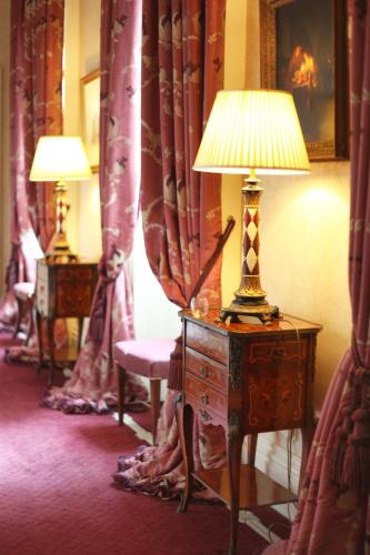 a lamp on a dresser in a room with curtains at Tankardstown House in Slane