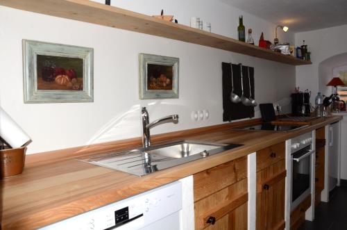 a kitchen with a sink and wooden counter top at Windshausen 84 in Nußdorf am Inn
