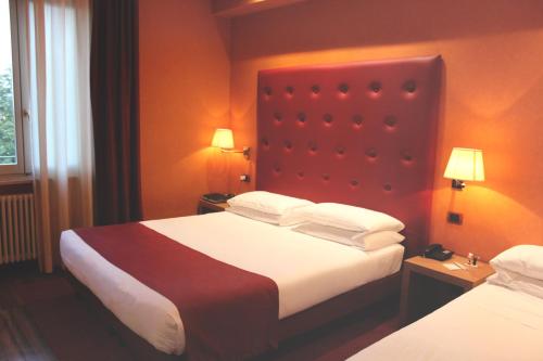 a hotel room with two beds and two lamps at Best Western Hotel Piemontese in Bergamo