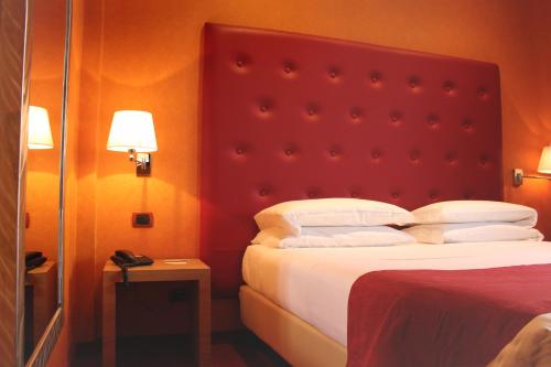 a hotel room with a bed with a red headboard at Best Western Hotel Piemontese in Bergamo