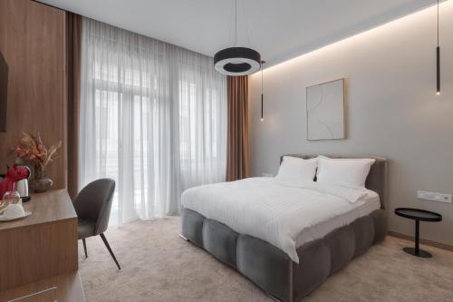 a bedroom with a large bed and a desk and a bed sidx sidx sidx sidx at Oasis Rooms Oradea in Oradea