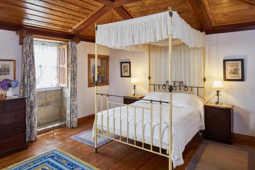 a bedroom with a canopy bed and a wooden ceiling at Casa de Canedo in Celorico de Basto