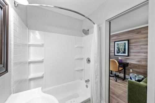 a bathroom with a shower and a white tub at Shores Inn & Hotel in Shediac