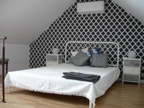 リスボンにあるApartamento Beco do Sapatoの白いベッドが備わる、模様のある壁のベッドルーム1室が備わります。