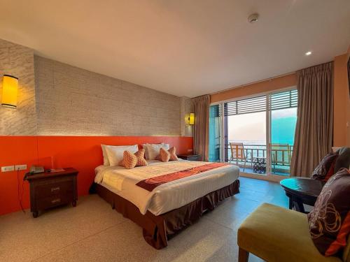 a bedroom with a bed with an orange wall at Seaside Jomtien Beach Pattaya in Jomtien Beach