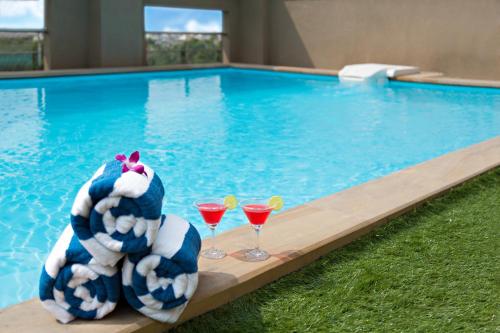 - une piscine avec deux verres de margaritas dans l'établissement Click Hotel, Junagadh, à Junagadh