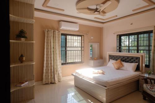 a bedroom with a bed and two windows at Simsar Villa Homestay in Bahāsi
