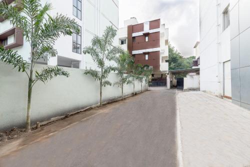an empty street in front of a building with trees at Treebo Trend Nestlay Casa in Chennai