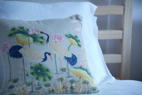 - un oreiller décoré sur le thème des oiseaux sur le lit dans l'établissement Pimenta Funchal Downtown, à Funchal