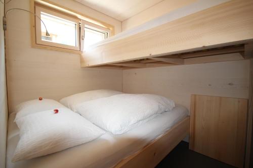 a small bedroom with a bed in a tiny house at Ferienwohnung Aviez Savognin in Savognin