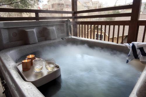a hot tub with glasses and candles on a balcony at Sweet Serenity in Gatlinburg