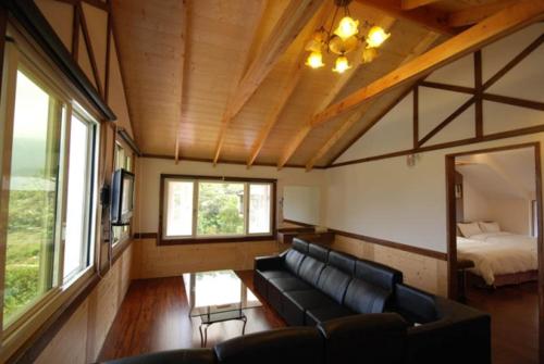 a living room with a couch and a bed at Natural Residence B&B in Taian
