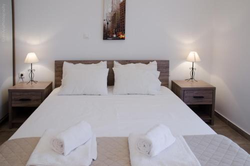 Epáno KefalásにあるVilla Sunriseのベッドルーム1室(白い大型ベッド1台、ナイトスタンド2台付)