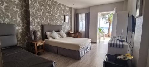 a bedroom with a bed and a television in a room at Down South 118 Beach Resort in Oslob
