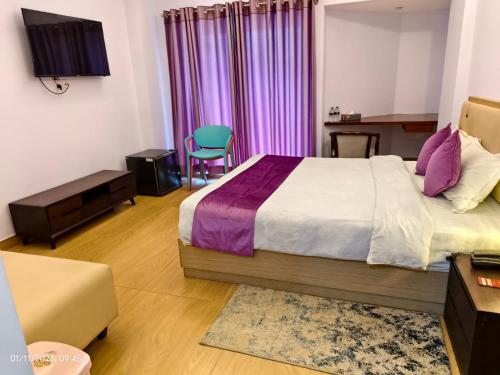 a bedroom with a bed and a desk and a chair at Best Southern Hotel in Kuākāta