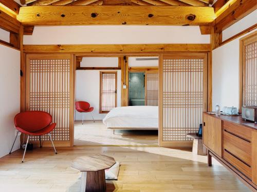 a bedroom with a bed and a red chair at soyeonjae 소연재 in Gyeongju