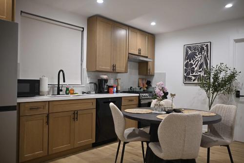 a kitchen with a table and chairs in a kitchen at Luxe Ensuite in Shared Home-Minutes to USC in Los Angeles