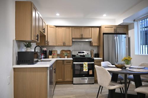 a kitchen with wooden cabinets and a table with chairs at Luxe Ensuite in Shared Home-Minutes to USC in Los Angeles