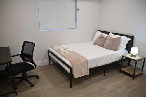 a bedroom with a bed and a desk and a chair at Luxe Ensuite in Shared Home-Minutes to USC in Los Angeles