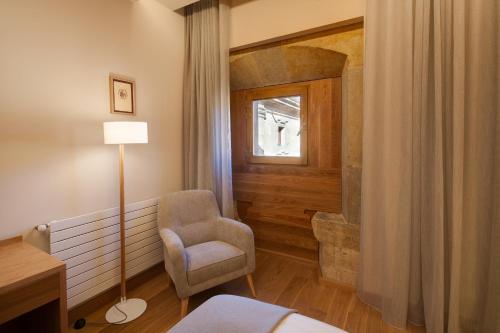 a hotel room with a chair and a window at Hotel Real Colegiata San Isidoro in León