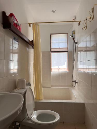 a bathroom with a toilet and a bath tub at Serenita Tagaytay in Kibagan