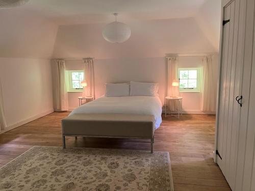 a bedroom with a bed with two lamps and a rug at 3 bedroom remote rural idyll on the North Downs in Faversham