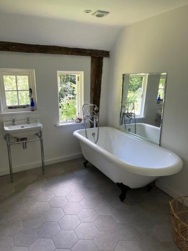 a bathroom with a white tub and a sink at 3 bedroom remote rural idyll on the North Downs in Faversham