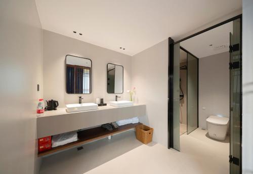 a bathroom with two sinks and a toilet at Zhangjiajie National Park East Gate Happy Hotel-River View&City Center&Book Tickets&English Speaking&Free Laundry in Hanqiyu