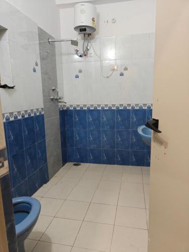 a bathroom with a blue toilet and a sink at Vijay Mansion Pratap Enclave in Jaipur