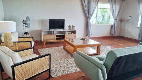 a living room filled with furniture and a tv at Stille Uitsig Hazyview in Hazyview