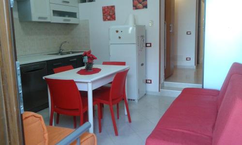 トラーパニにあるCasa San Liberaleのキッチン(白いテーブル、赤い椅子付)