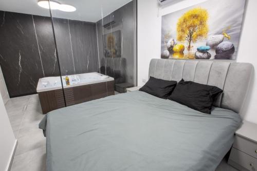 a bedroom with a large bed and a sink at חוויה בכיכר גולד in Netanya