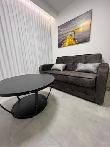 a living room with a couch and a table at חוויה בכיכר גולד in Netanya