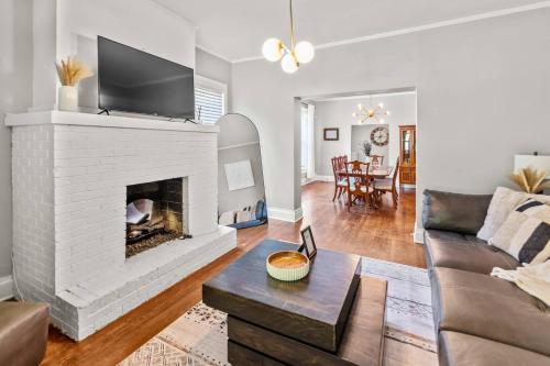 a living room with a white brick fireplace at Annesdale #1 - Spacious & Central 3BR in Midtown! in Memphis