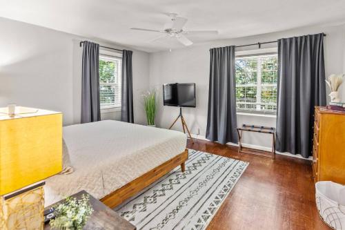 a bedroom with a bed and a flat screen tv at Annesdale #1 - Spacious & Central 3BR in Midtown! in Memphis