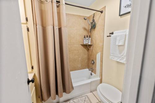 a bathroom with a tub and a toilet and a sink at Annesdale #1 - Spacious & Central 3BR in Midtown! in Memphis